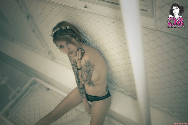 Сексуальная татуированная девочка позирует голая в цепях